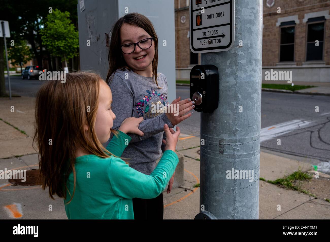 Sisters playing with buttons at a stop light Stock Photo
