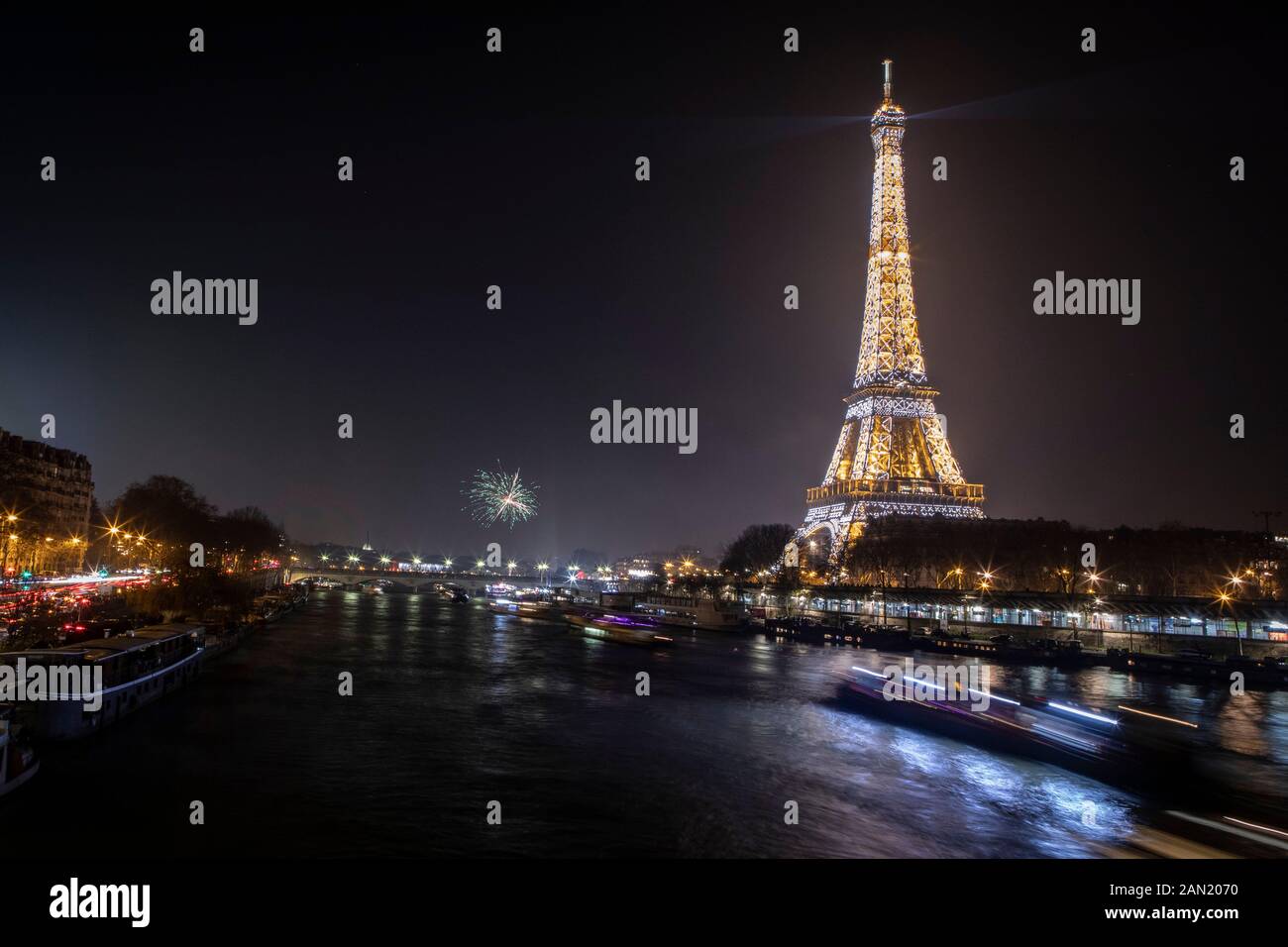 Lights and fireworks at the Eiffel Tower mark midnight on New Years. Stock Photo