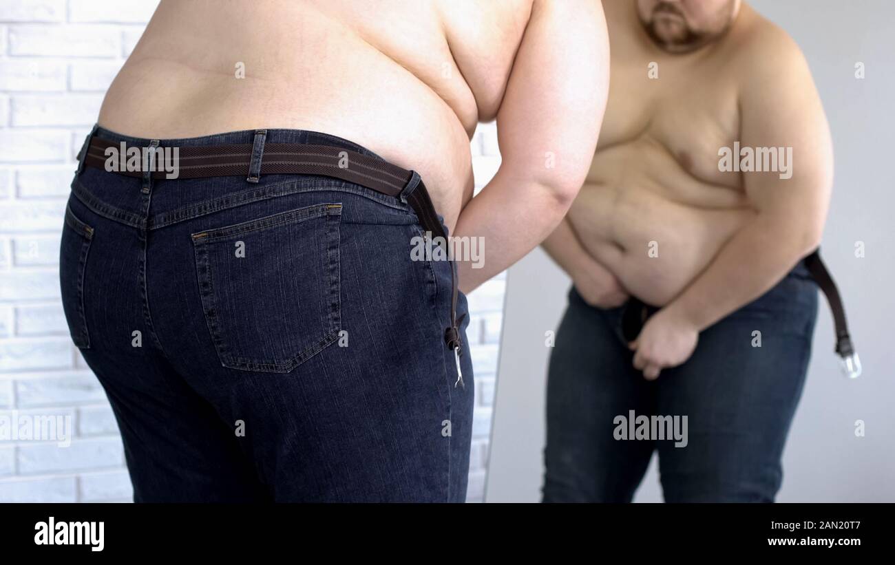 Fat man trying to button up tight jeans 