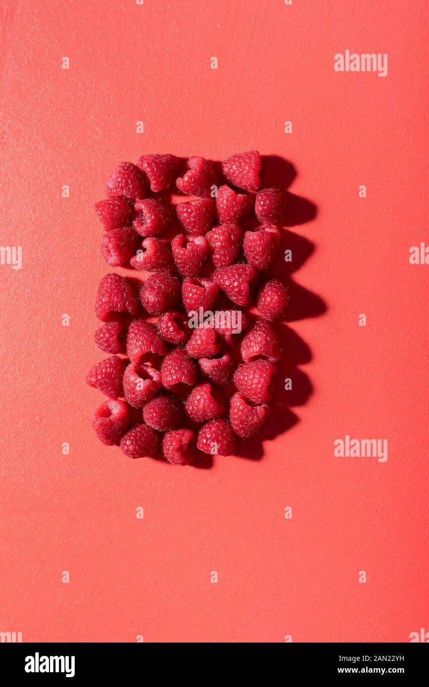 R Shaped Raspberry Raspberry pile in a rectangle shape on a lush lava table. Above view of ...