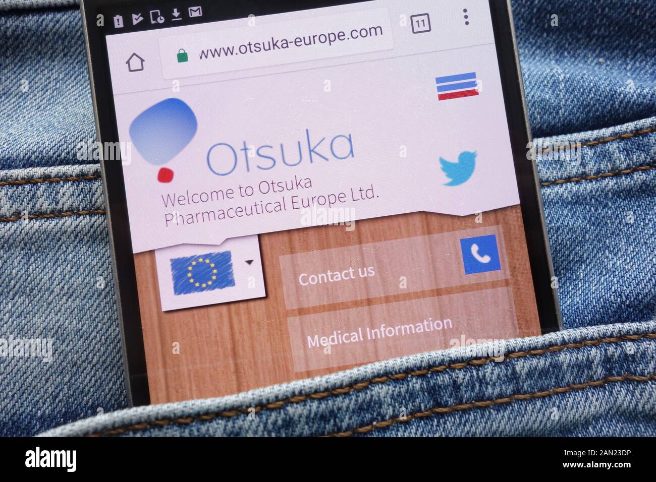 Otsuka Pharmaceutical Europe website displayed on smartphone hidden in jeans pocket Stock Photo