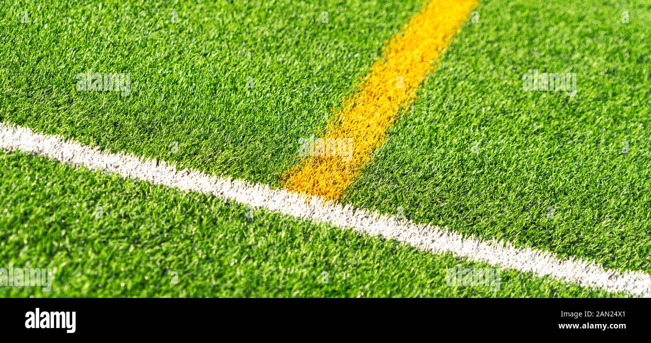 Green artificial grass turf soccer football field backgrond with white and yellow line boundary