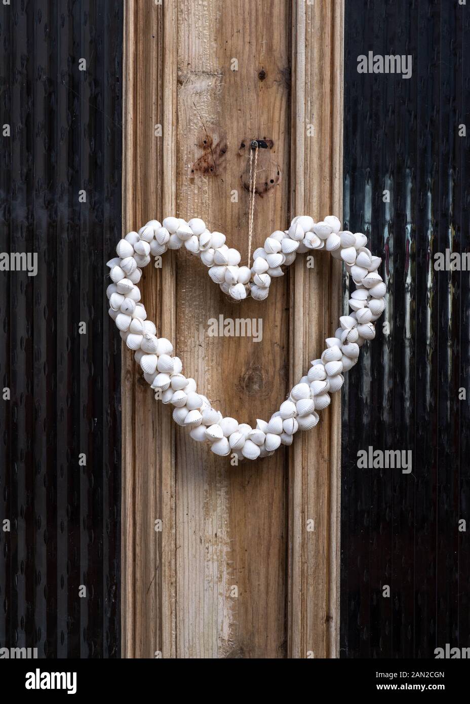 Close up of wooden doorway with white shell heart decorative detail and glass window panes Stock Photo