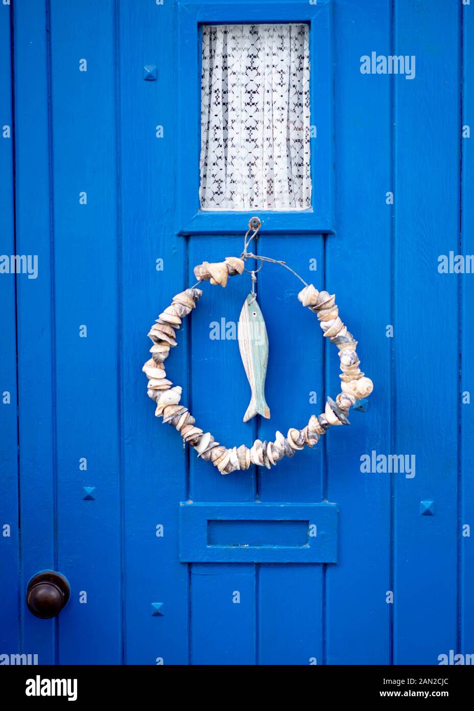 Close up image of blue front door on residential property in Appledore street with art work hanger door decoration Stock Photo