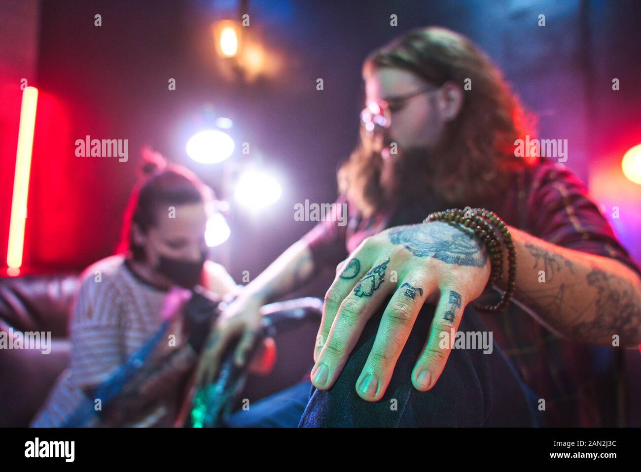 People Getting Tattoo In Studio With Professional Tattooist Working Stock Photo