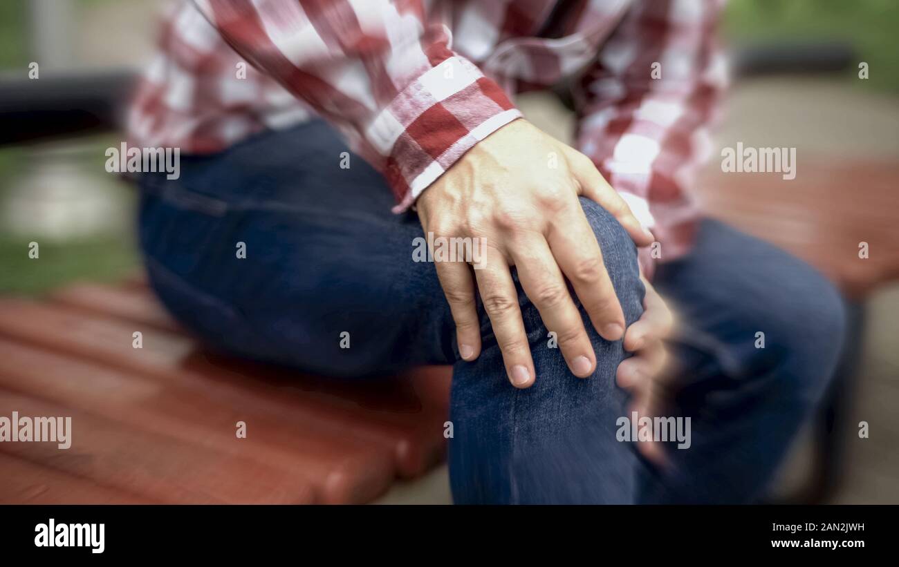 Male suffers from knee pain, injured joint, arthritis, blurred effect