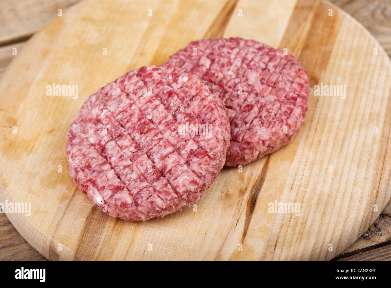 Soft focus. Two raw pink beef cutlets on a cutting board.. Copy space. Stock Photo