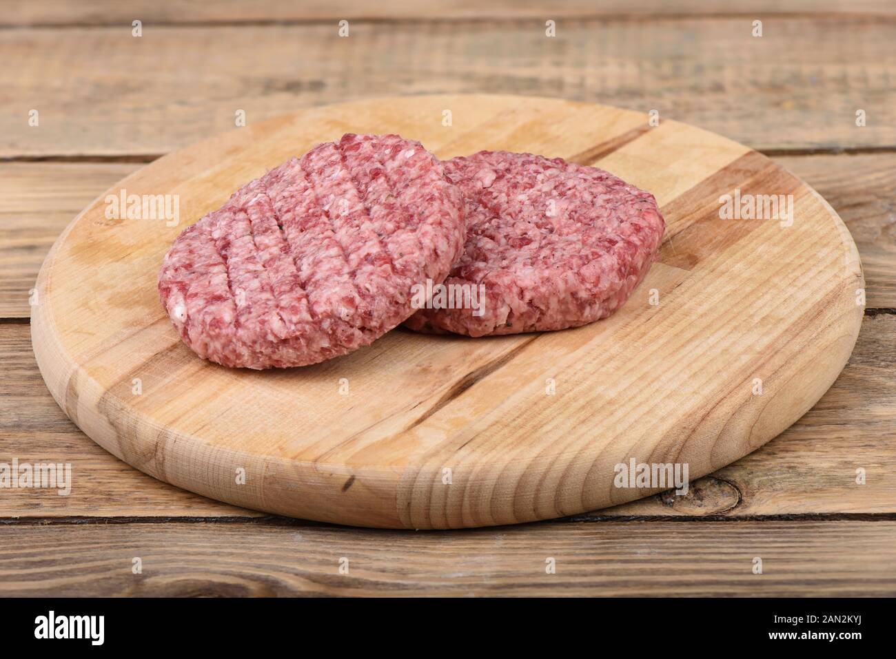 Two raw pink beef cutlets on a cutting board.. Copy space. Rustic style. Stock Photo