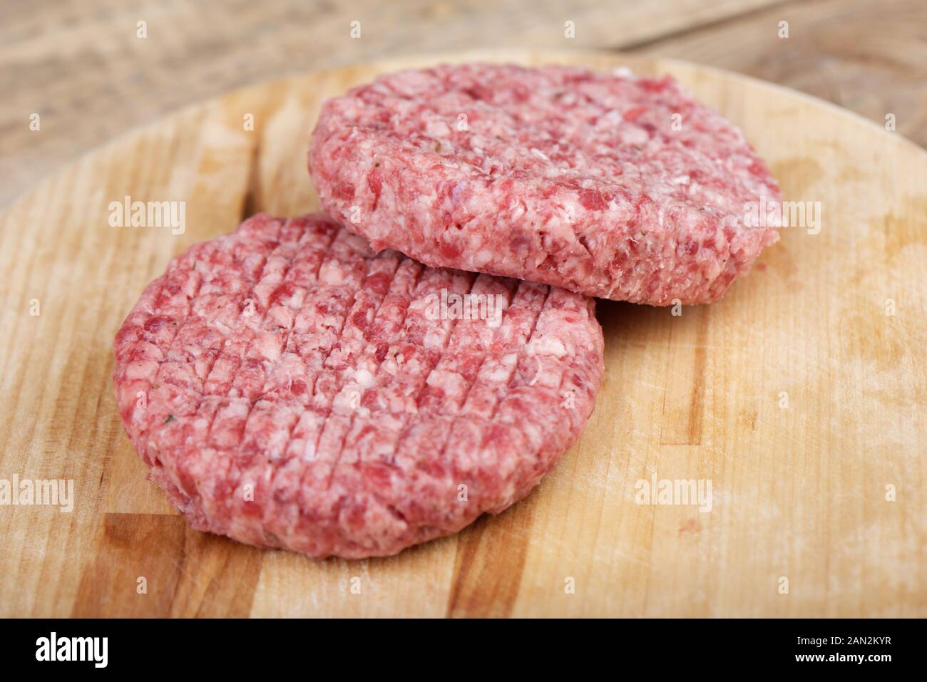 Soft focus. Two raw pink beef cutlets on a cutting board.. Copy space. Stock Photo