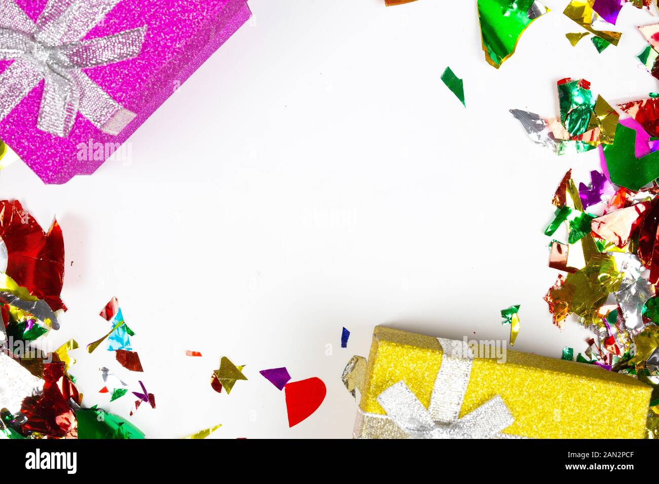 Multi-colored confetti and colorful presents isolated on white ...