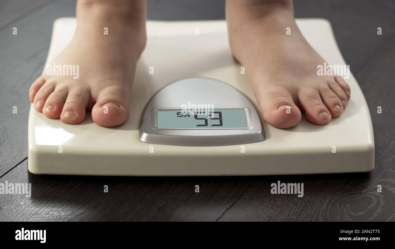 https://c8.alamy.com/comp/2AN2T75/female-standing-on-scales-to-see-weight-control-result-healthy-dieting-frontal-2AN2T75.jpg