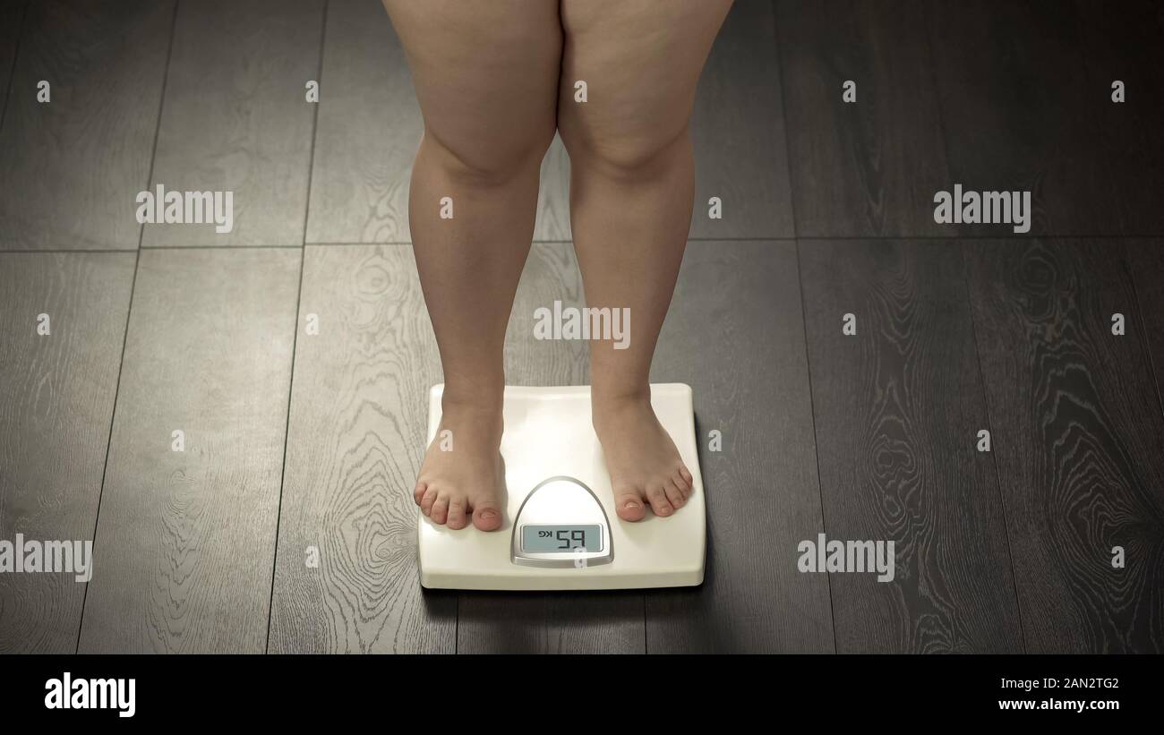 https://c8.alamy.com/comp/2AN2TG2/chubby-female-standing-on-scales-checking-weight-after-diet-body-control-2AN2TG2.jpg