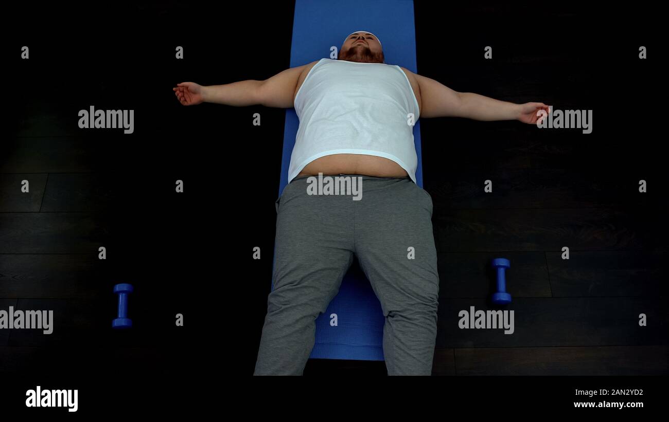 Unmotivated fat male lying on mat, tired of exercise, weight loss problem Stock Photo Alamy