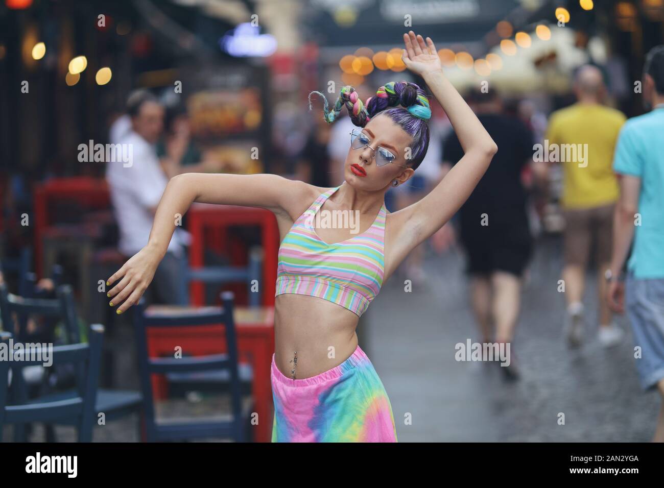 Eccentric Young Woman dancing in the middle of a crowded Street - Freedom concept Stock Photo