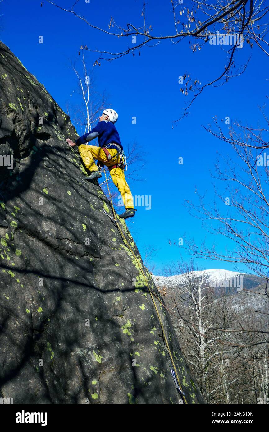 Male rock climber, 70 years old, climbing on granite cliff at Auzat, French Pyrenees, France Stock Photo