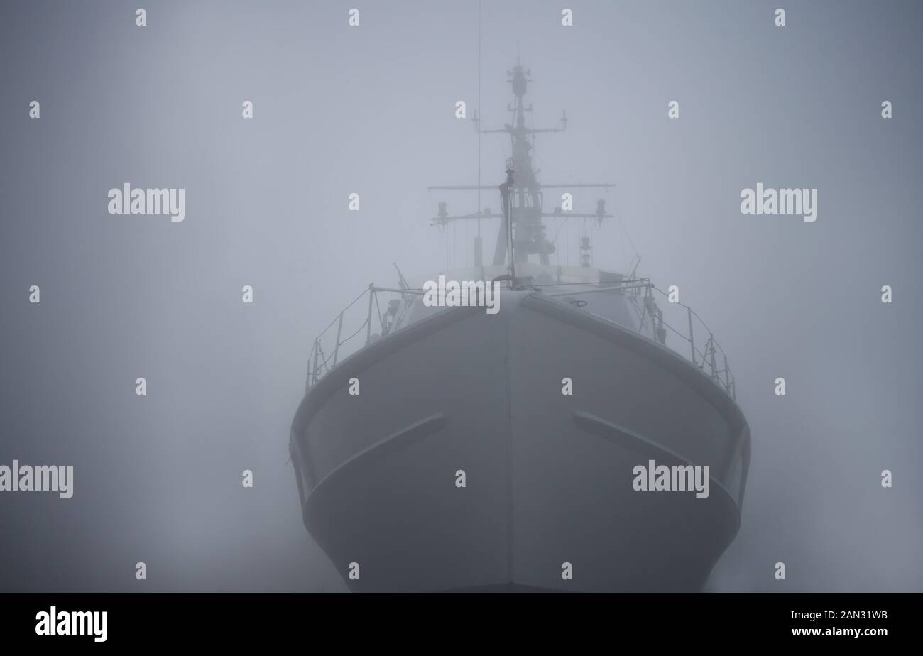 Ghost ship. Warship in the fog or mist as a flying Dutchman. Gray color. Mystery concept. Pirate Code, doomed vessel rise from the sea, spreading Stock Photo