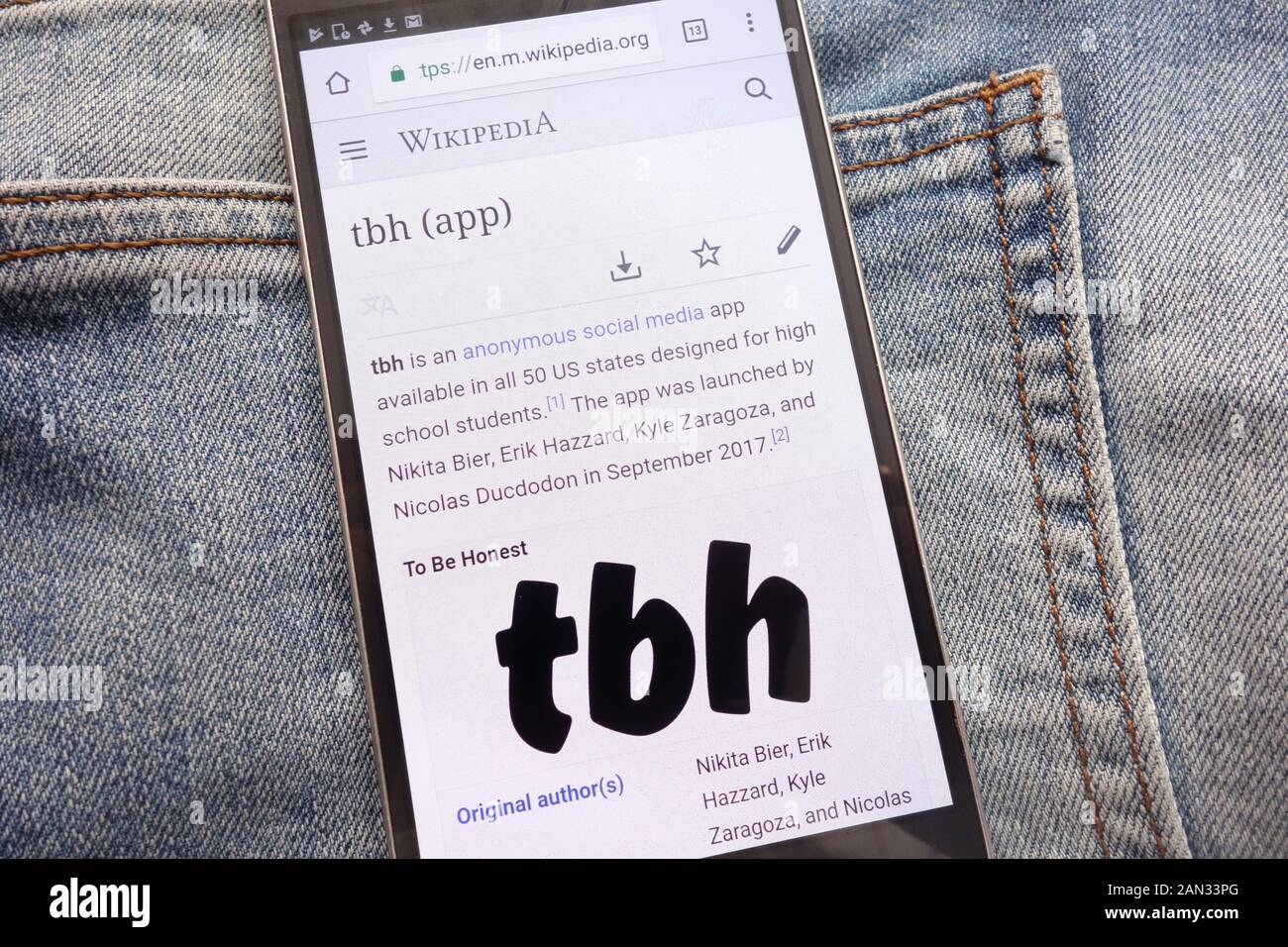 Article about tbh app on Wikipedia website displayed on smartphone hidden in jeans pocket Stock Photo