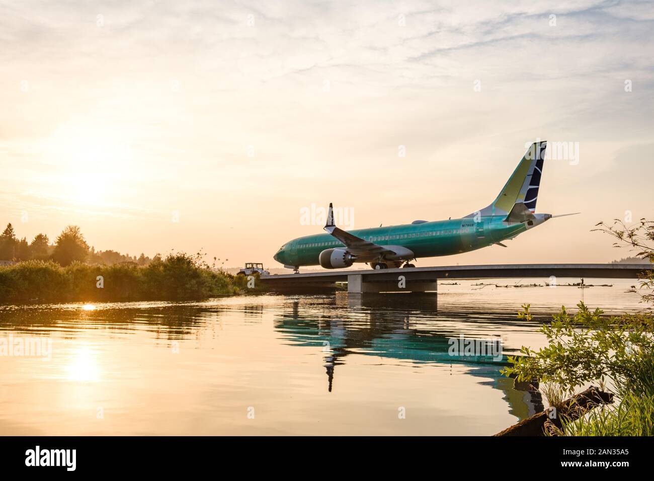 Newly Assembled 737 MAX airplanes are towed across the Cedar River from the Factory to Renton Field to begin testing prior to their first flight Stock Photo