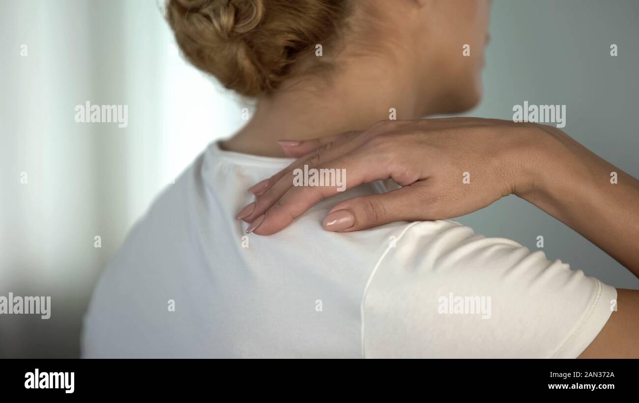 Woman feeling pain in shoulder after workout, muscle soreness, health care Stock Photo