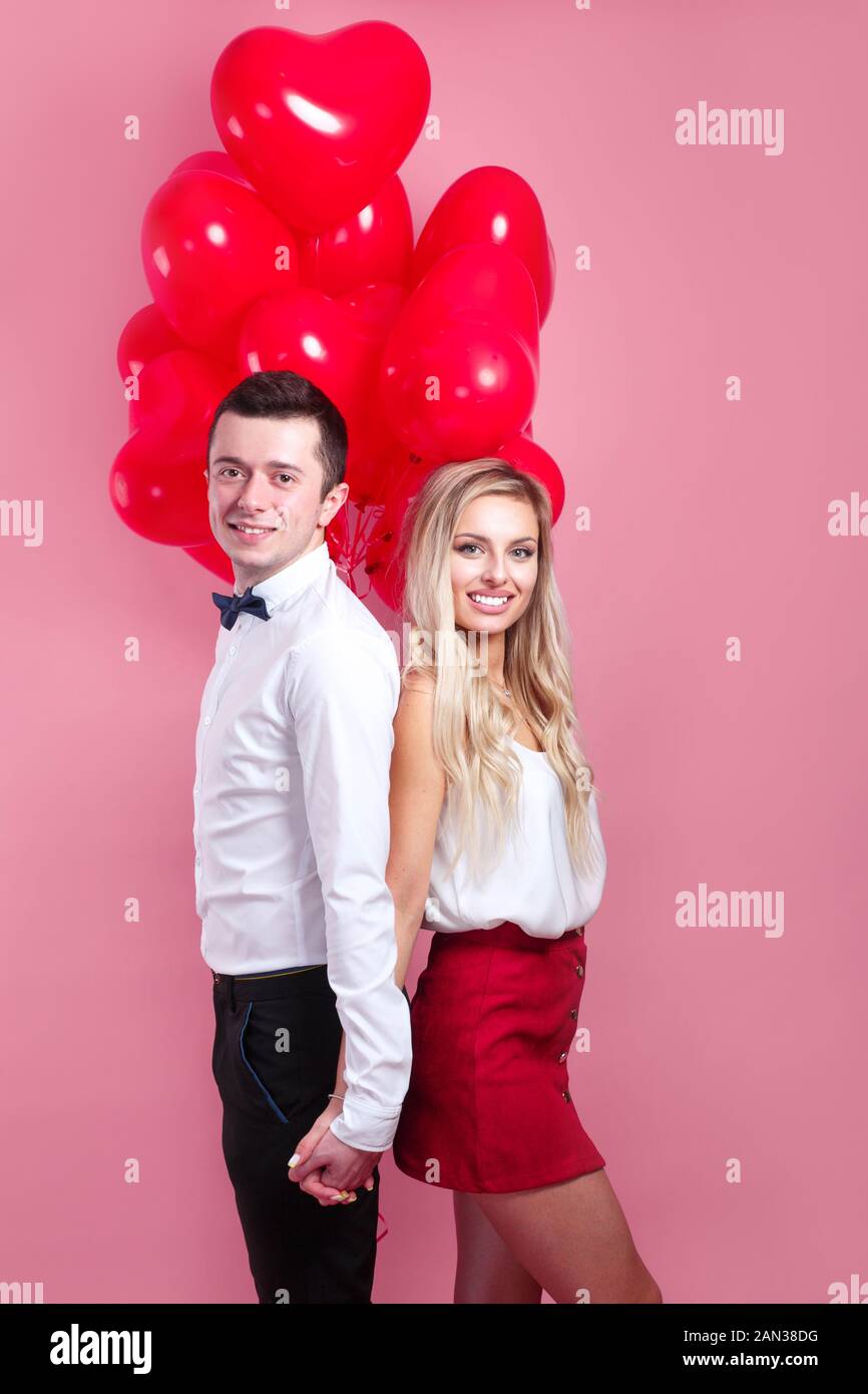 young loving couple with balloons heart on pink background Stock Photo ...