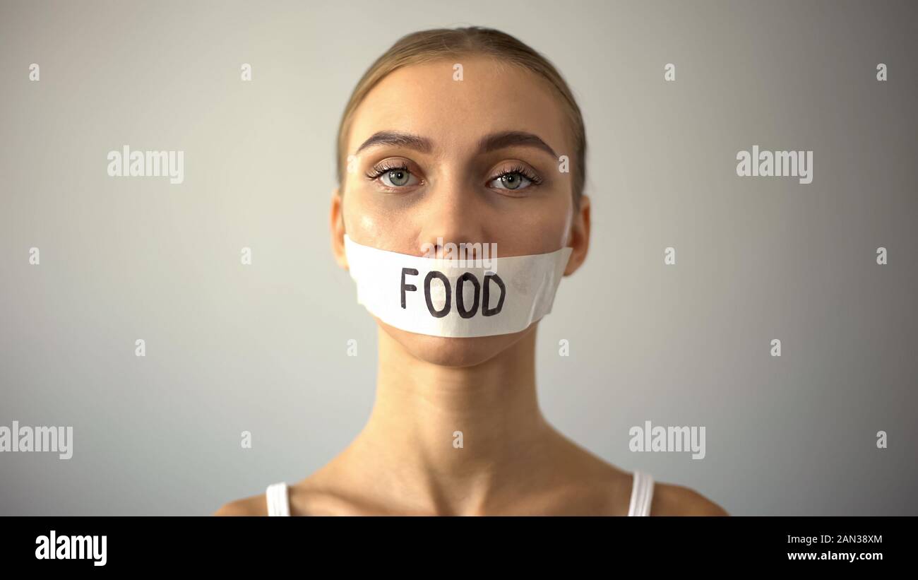 Thin model with taped mouth, concept of food restriction and anorexia, diet Stock Photo