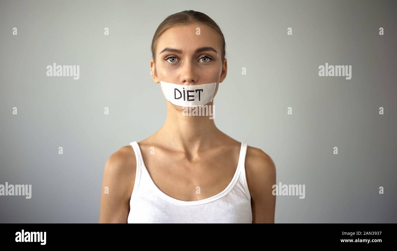 Diet word written on taped mouth of anorexic model, severe diet, health problems Stock Photo
