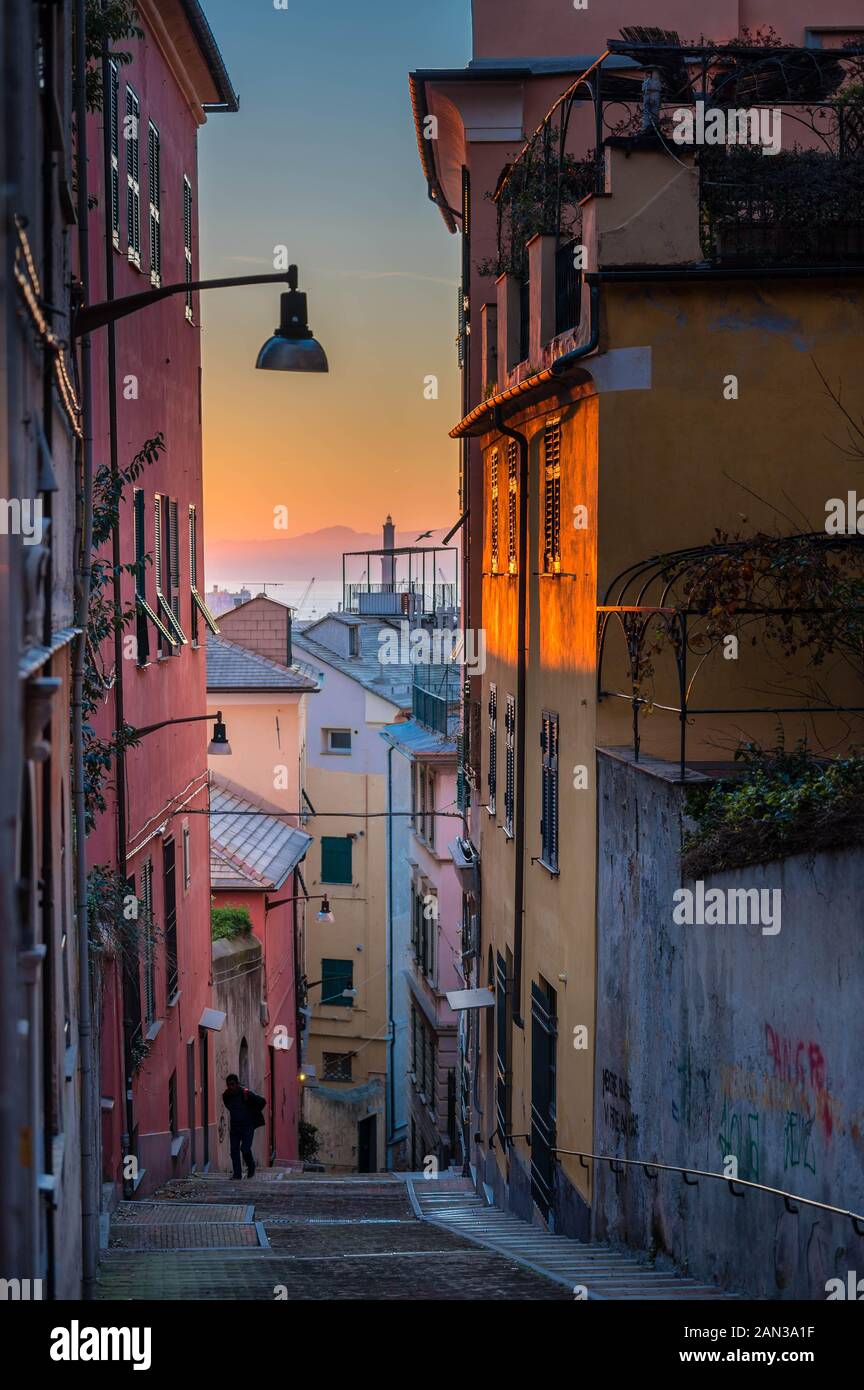 Genoa, Genova: Lanterna (lighthouse) view from the characteristic typical colorful narrow alleys (caruggi, vicoli) and colored houses of old town Stock Photo