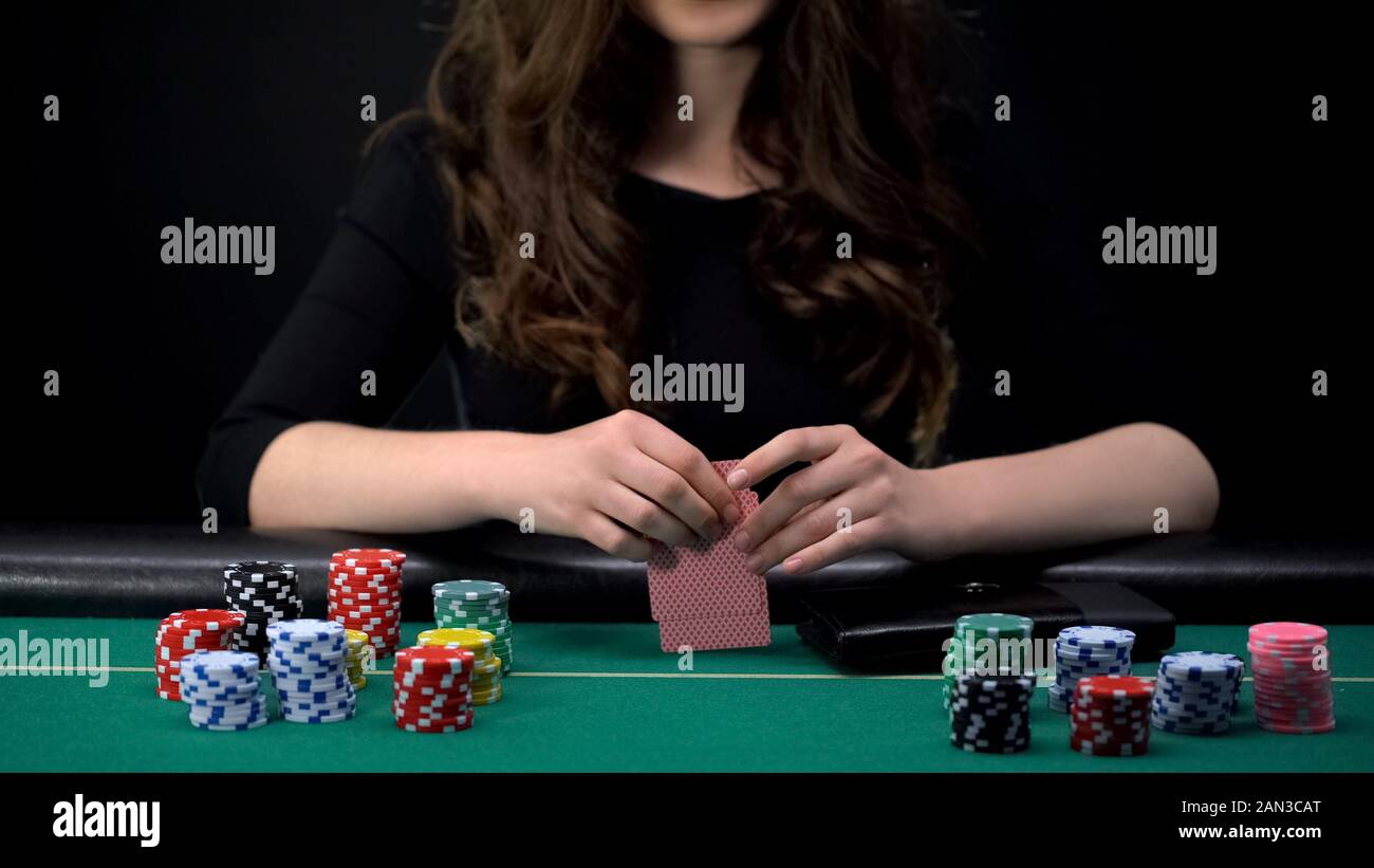 Female casino player checking cards combination, woman taking risk in poker game Stock Photo