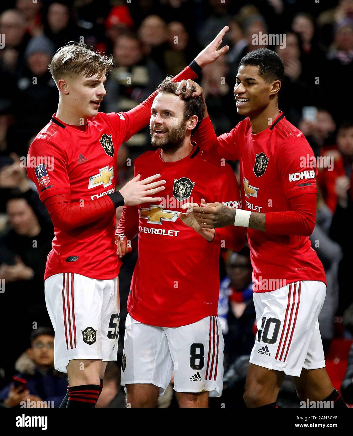 Manchester United's Juan Mata (centre) celebrates scoring his side's first  goal of the game with team-mates Brandon Williams (left) and Marcus  Rashford during the FA Cup third round replay match at Old