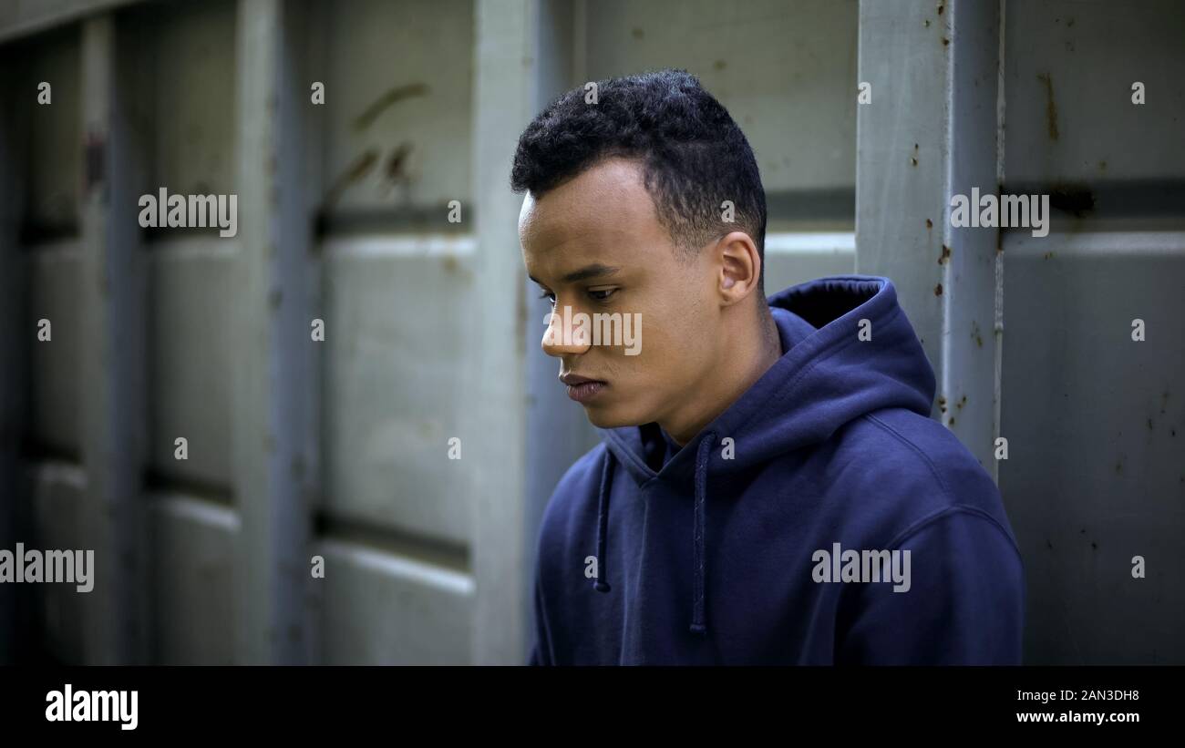Despair african american boy planning crime, hopelessness caused by poverty Stock Photo
