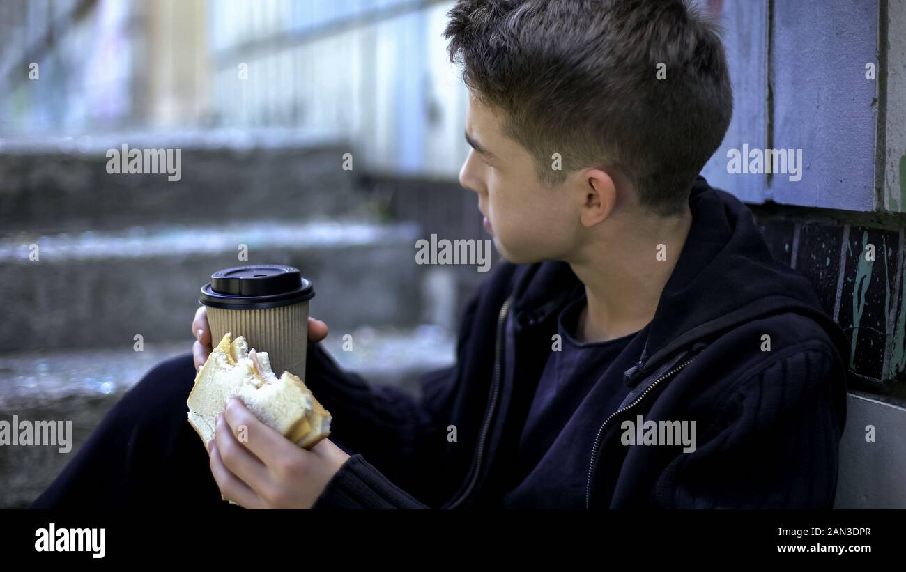 Bullying by senior students, schoolboy eating lunch around school corner alone Stock Photo