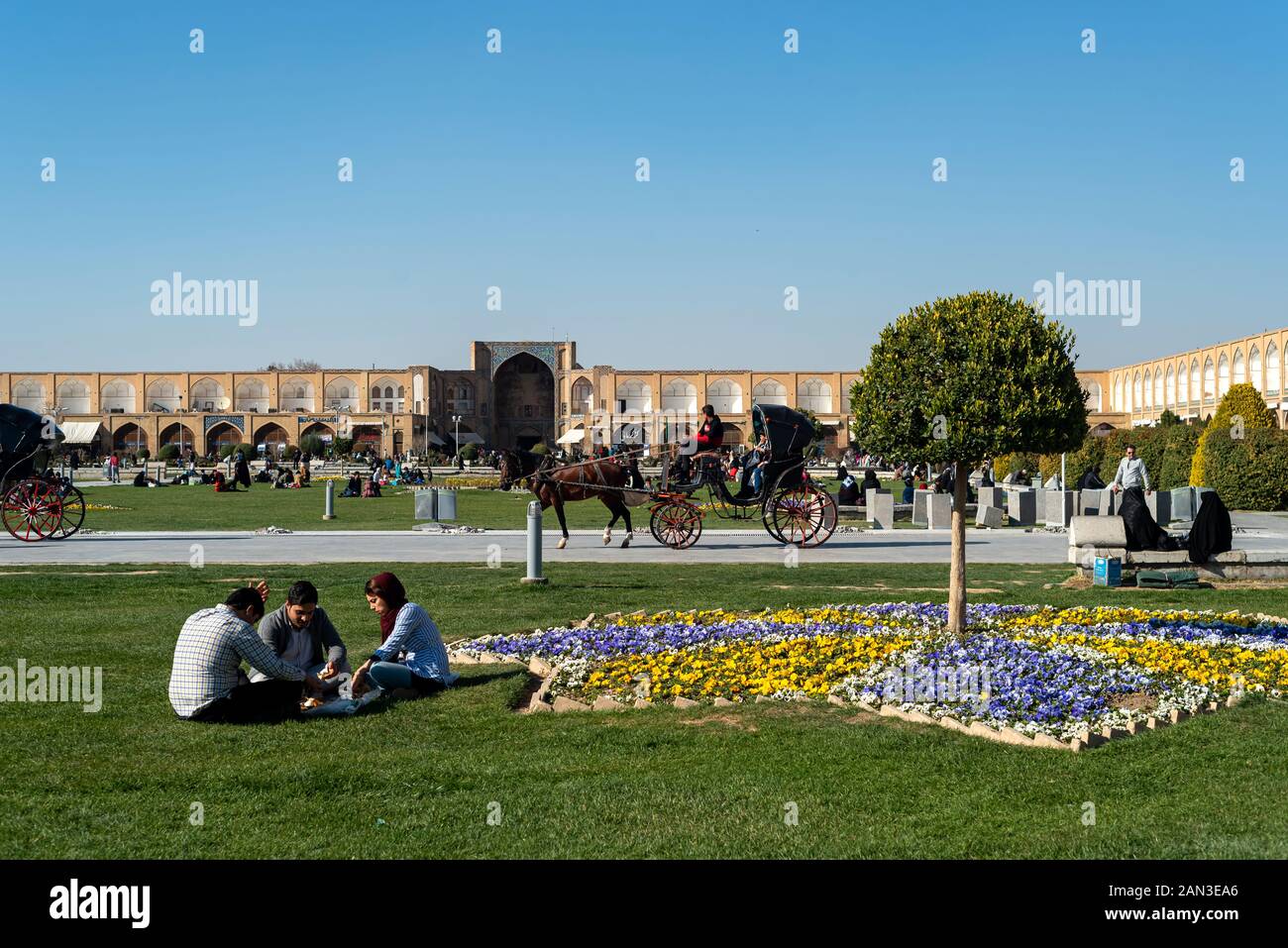 March 2, 2019: Iranian people resting and having a pic nic on the grass at Naghsh-e Jahan Square. Isfahan, Iran Stock Photo