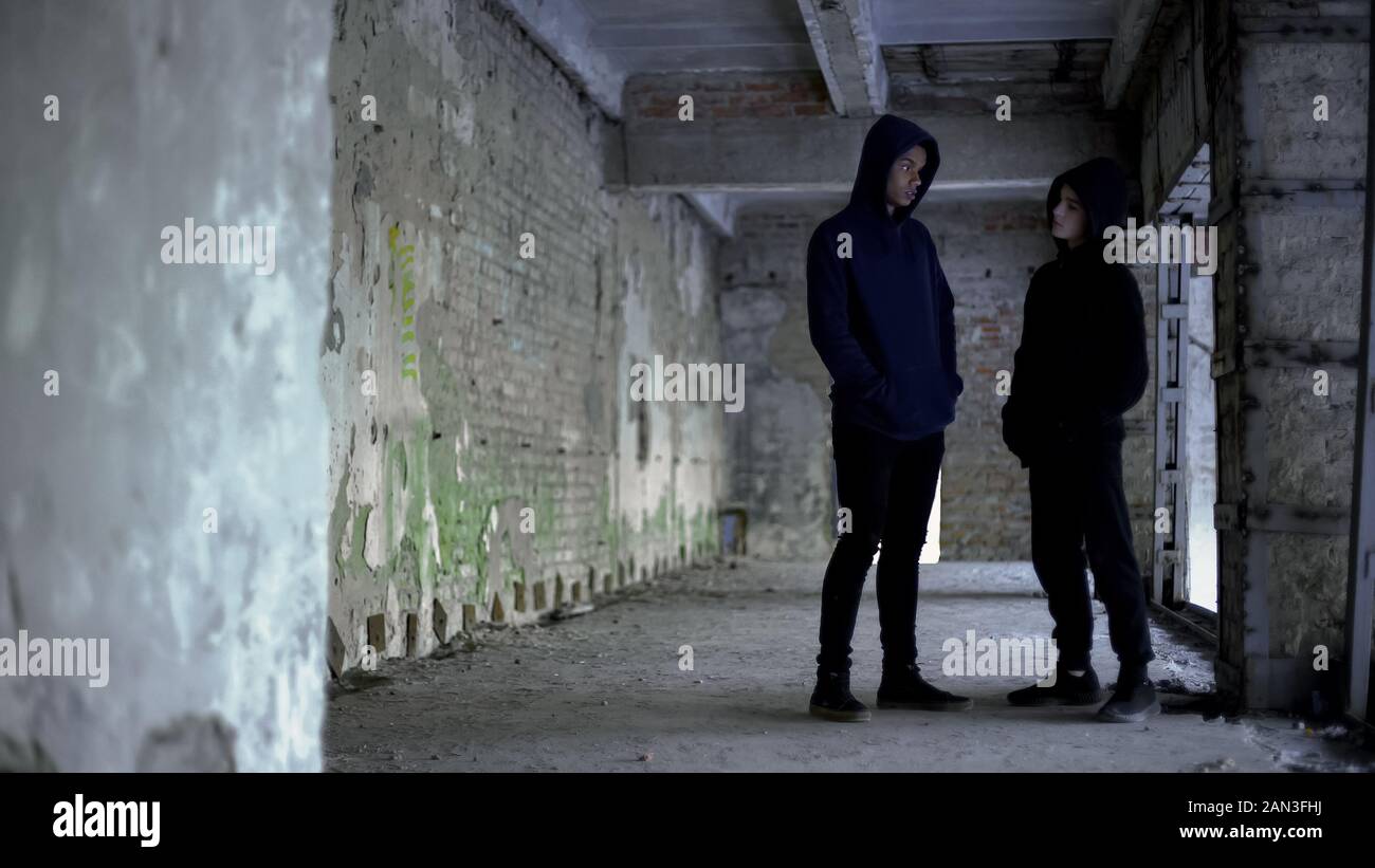 Boys in hoodie talking in ruined building, teenage gang, young criminals Stock Photo