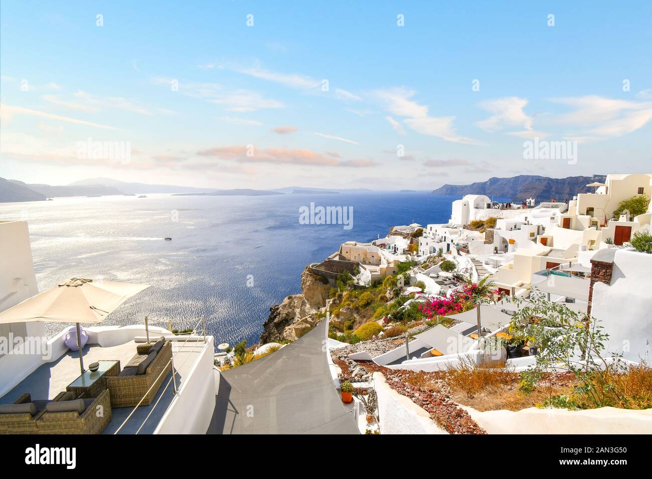 A terrace overlooks the whitewashed town of Oia, Greece and blue Aegean sea on the island of Santorini, Greece. Stock Photo