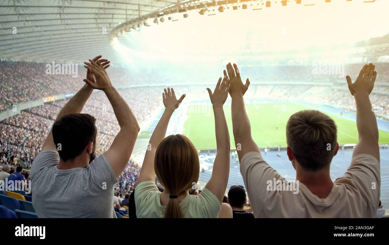 Football fans raising hands, chanting, supporting national team at stadium Stock Photo Alamy