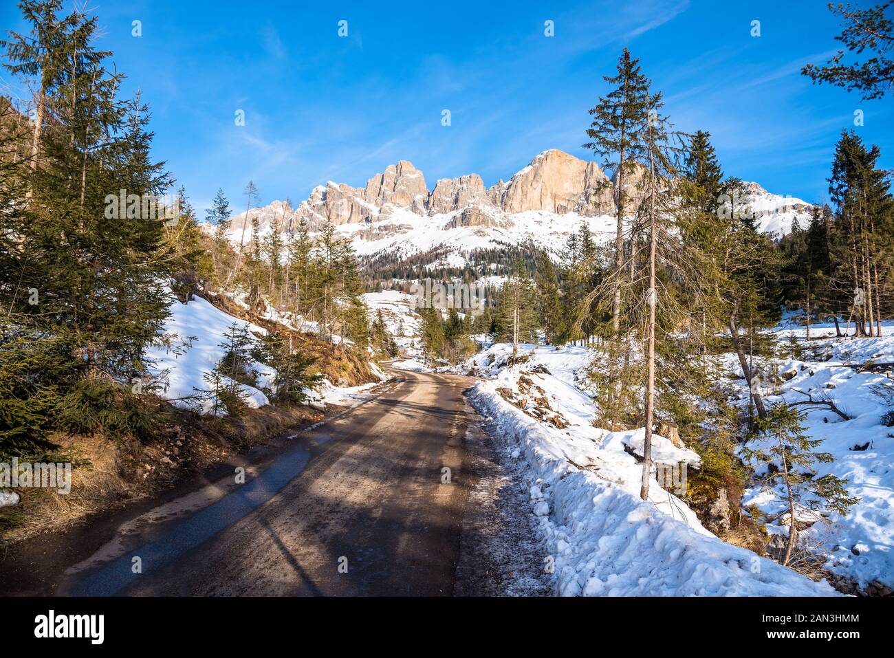 Empty winding road in a magnificent snowy mountain scenery in the Alps ...