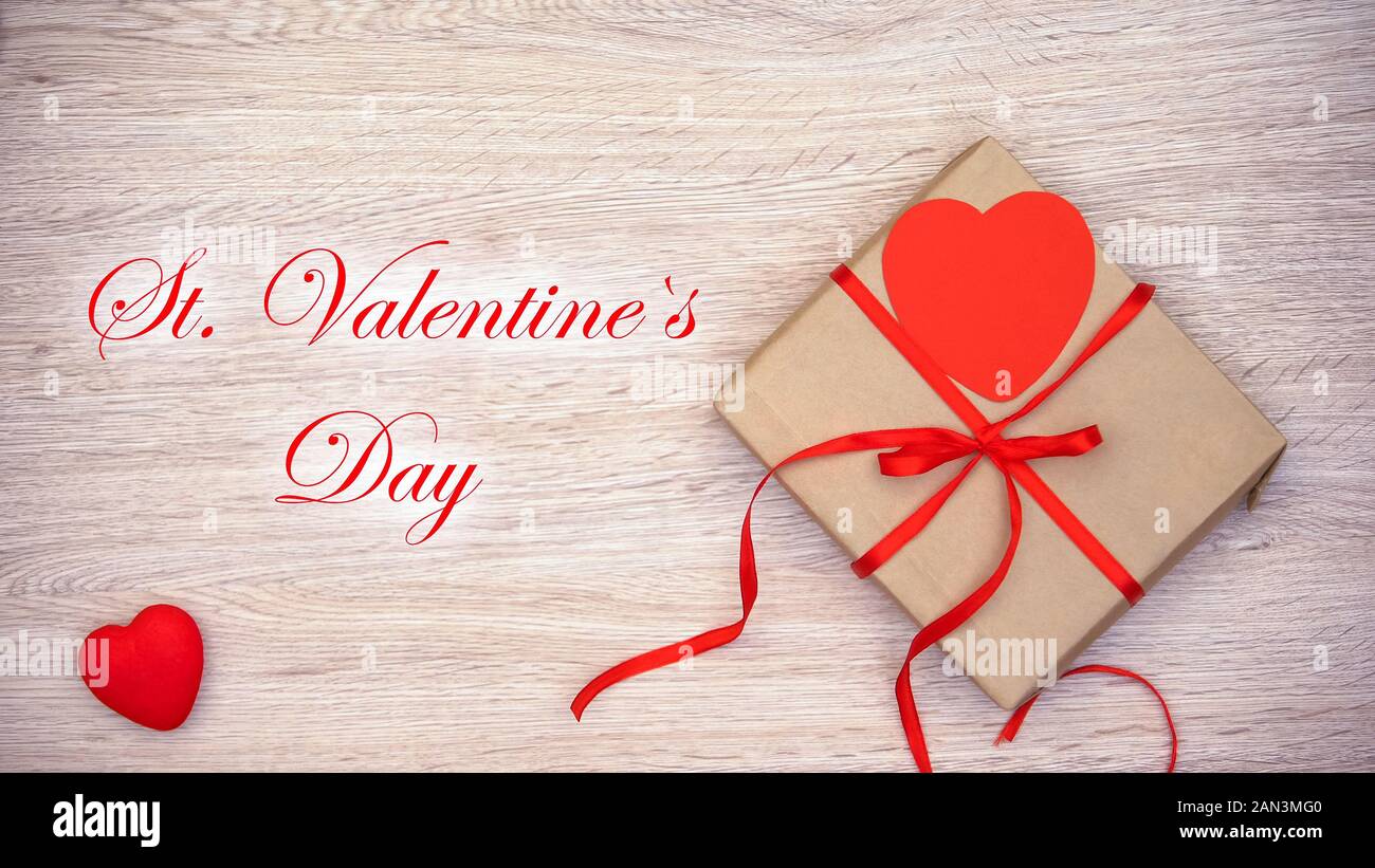 St Valentines Day phrase appearing on wooden background with craft gift box Stock Photo