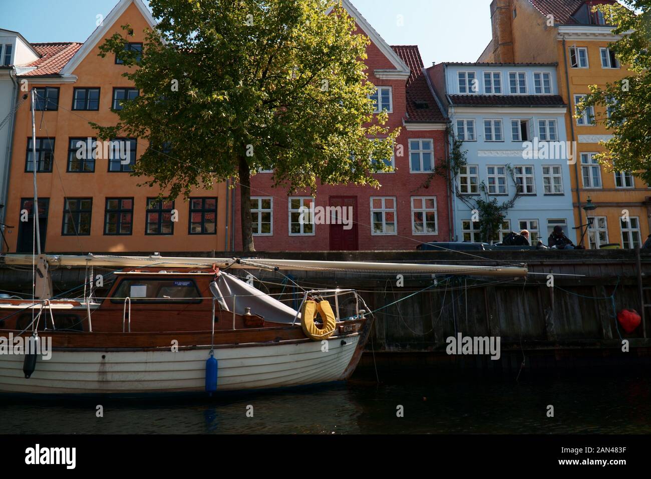 Boat in front of colourful houses by the canal in Copenhagen, Denmark Stock Photo