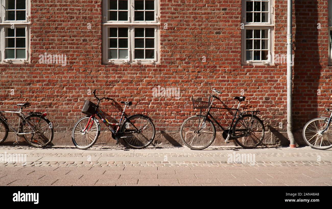 Bicycles parked against a brick wall in Copenhagen, Denmark Stock Photo