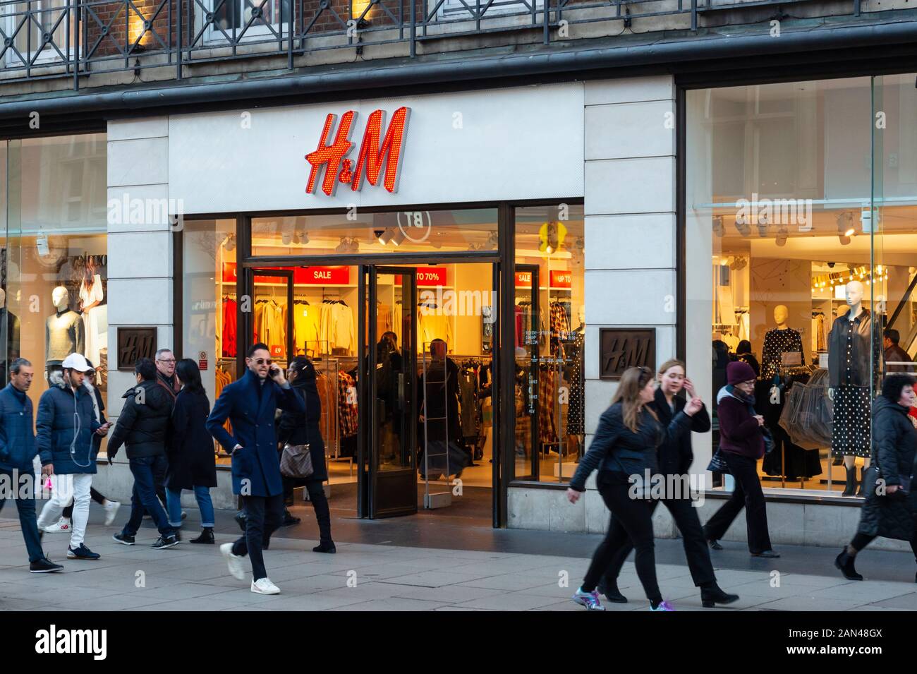People walking past the H&M retail store shopfront in Oxford Street, London, UK Stock Photo