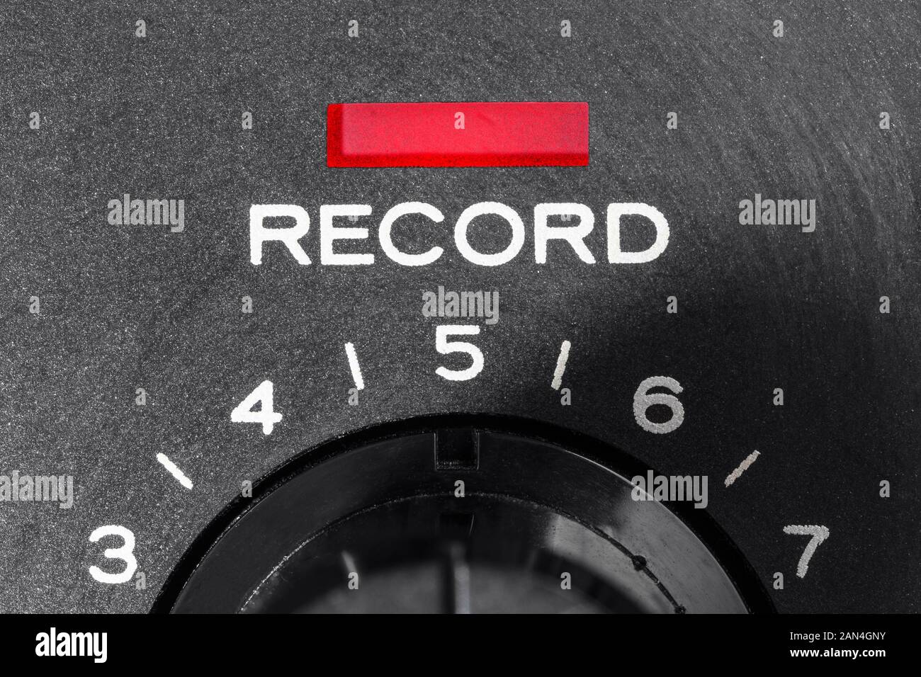 Macro close up photograph of vintage tape machine record control dial and indicator light. Stock Photo
