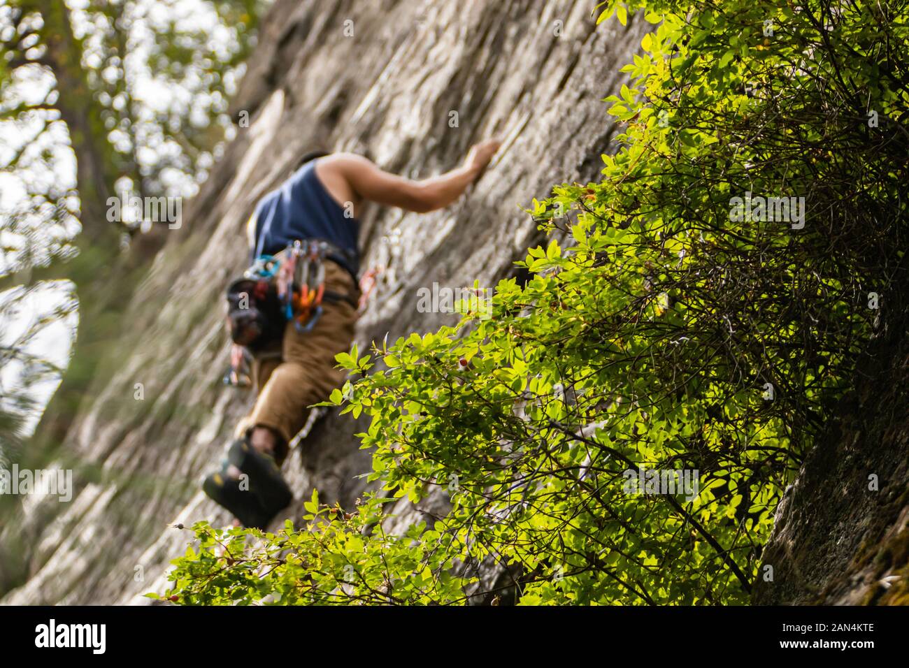 A low angle and selective focus view of a professional rock climber
