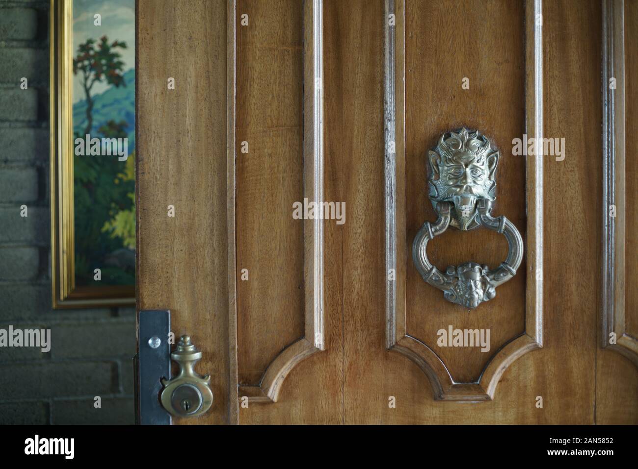 A bronce lion door handle in a heavy wooden door Stock Photo