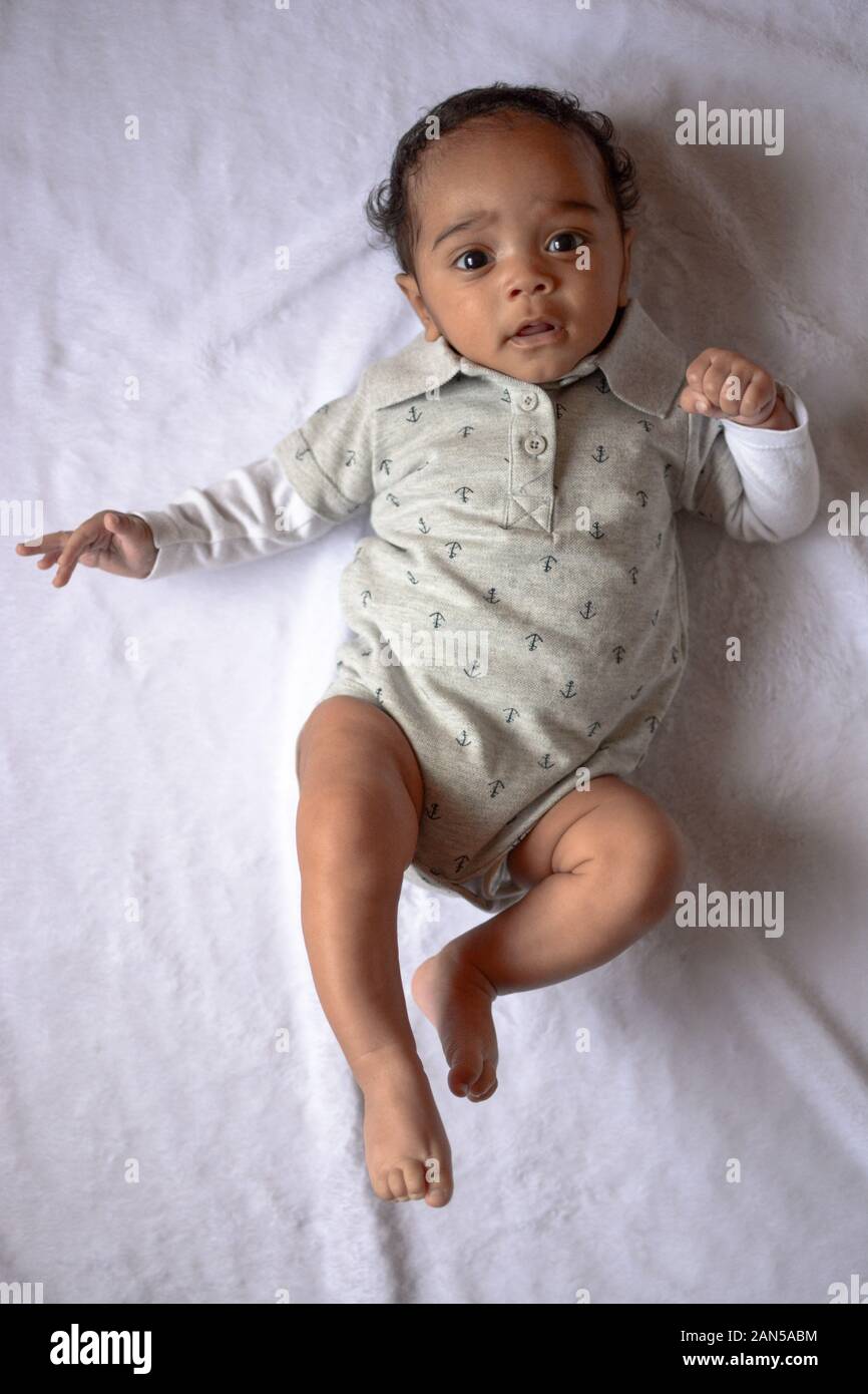 Young baby boy shot from directly above while laying on bed Stock Photo