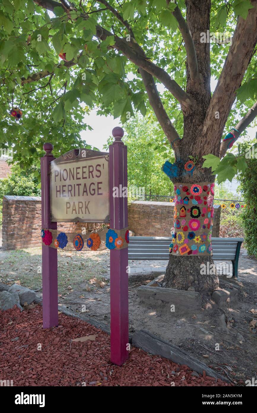 The Pioneers Heritage Park in Lithgow includes a memorial to the pre 1856 pioneers of the local district. The park sign and tree have been yarn bombed Stock Photo