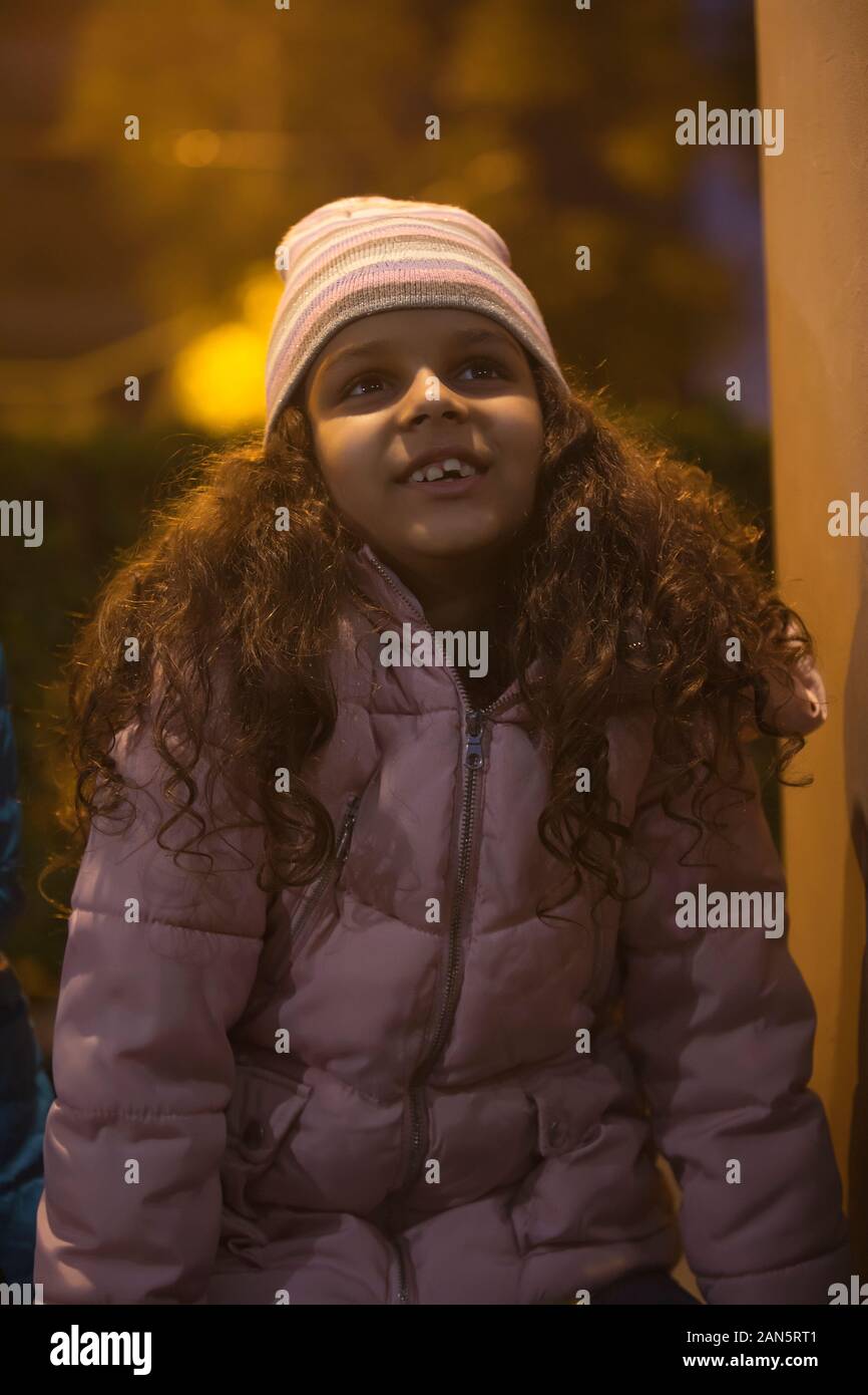 Young girl wearing a beanie looking up 