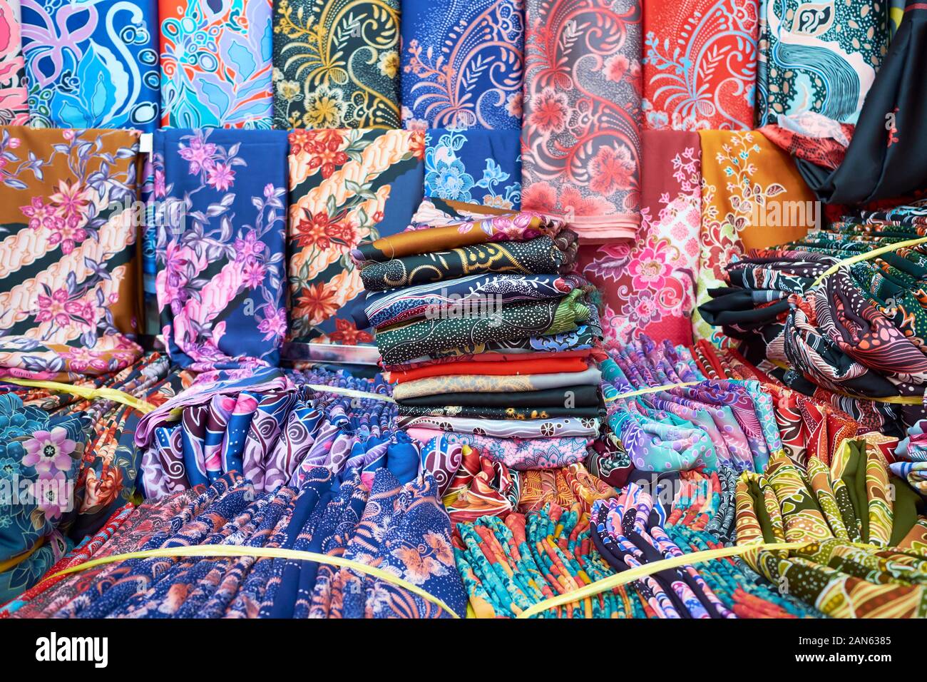 Many bundles and samples of traditional Malay clothing, material