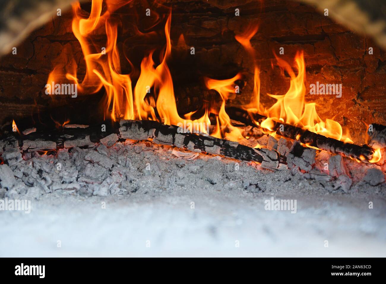 fireplace with log wood burning clay stove fire in home in the winter