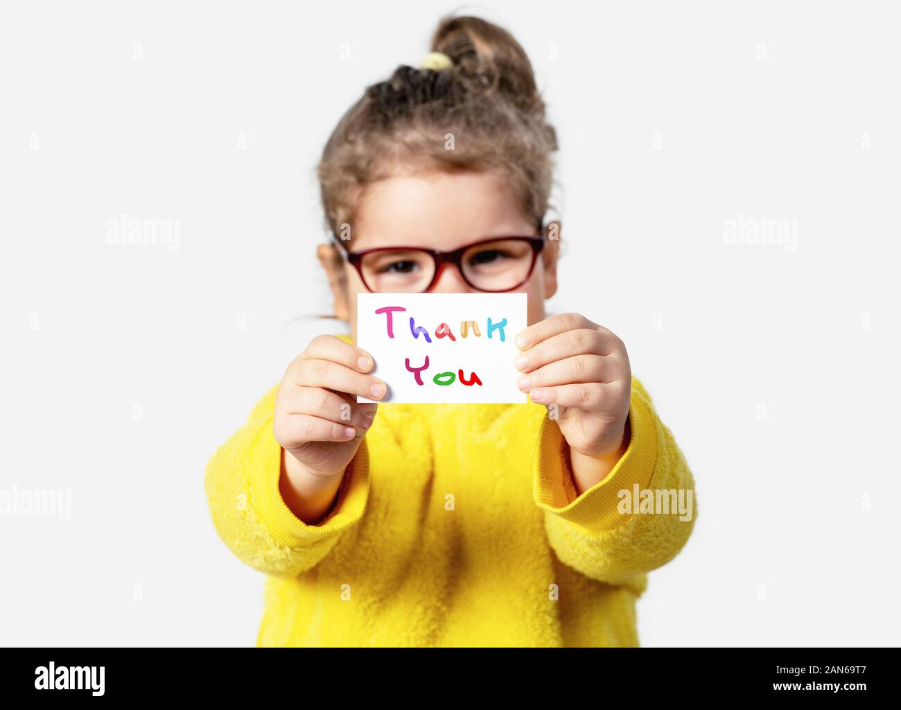 Adorable baby girl is holding a paper with a Thank you note. Silent communication concept Stock Photo