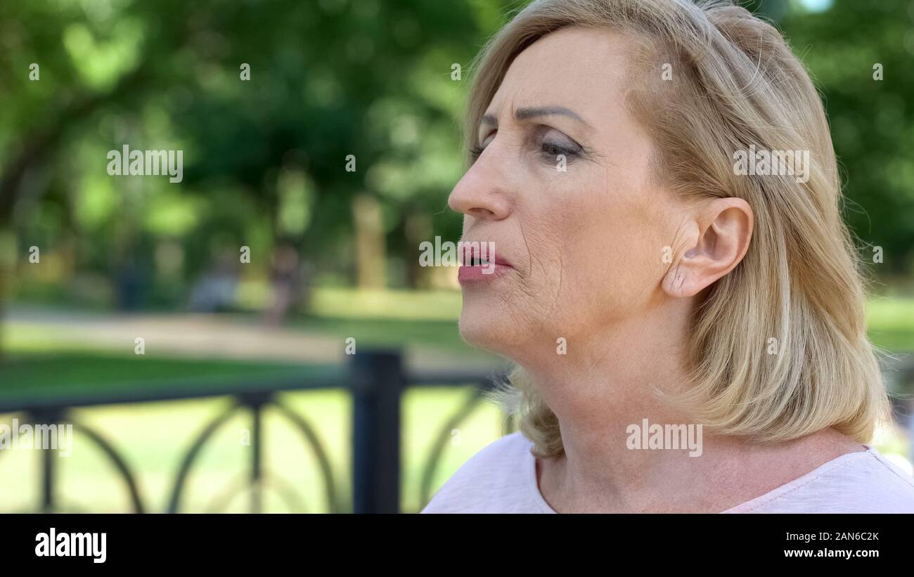 Aging woman doing breathing exercises in park, active lifestyle, healthcare Stock Photo
